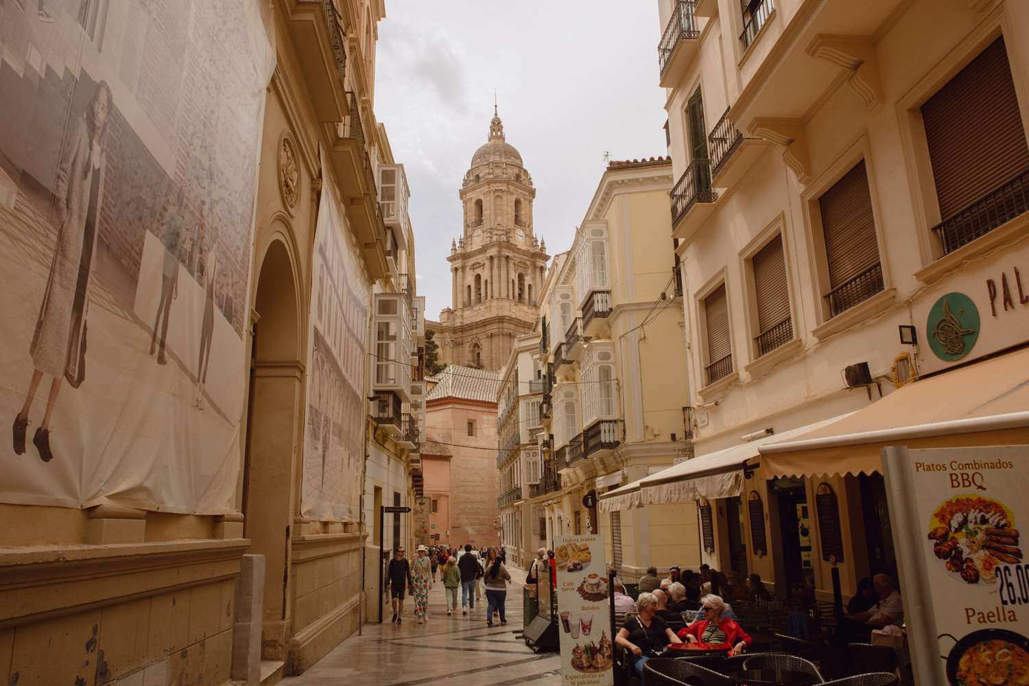 Vue d'une longue rue avec une église imposante à Málaga