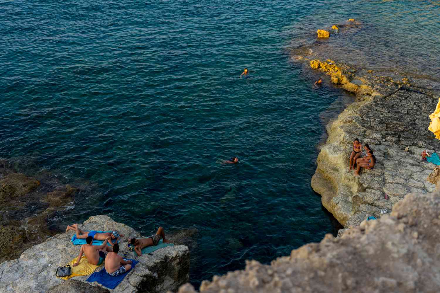 Vue de personnes sur les arêtes rocheuses d'Ortigia au bord de la mer