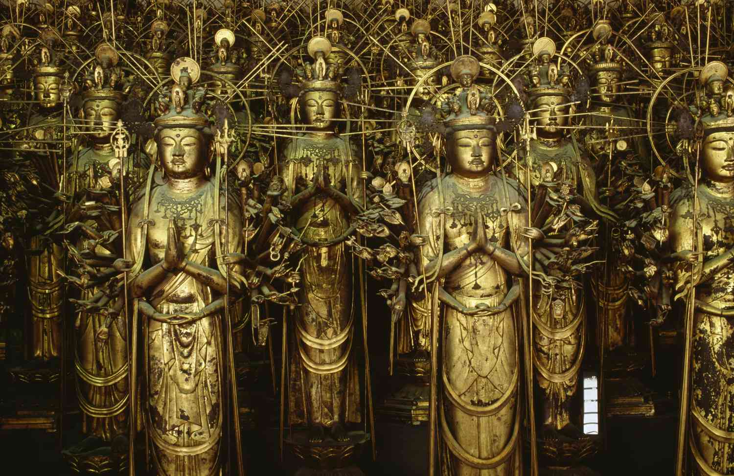 many statues of Kannon the godesss of mercy with her hands in prayer at Sanjusangendo Temple