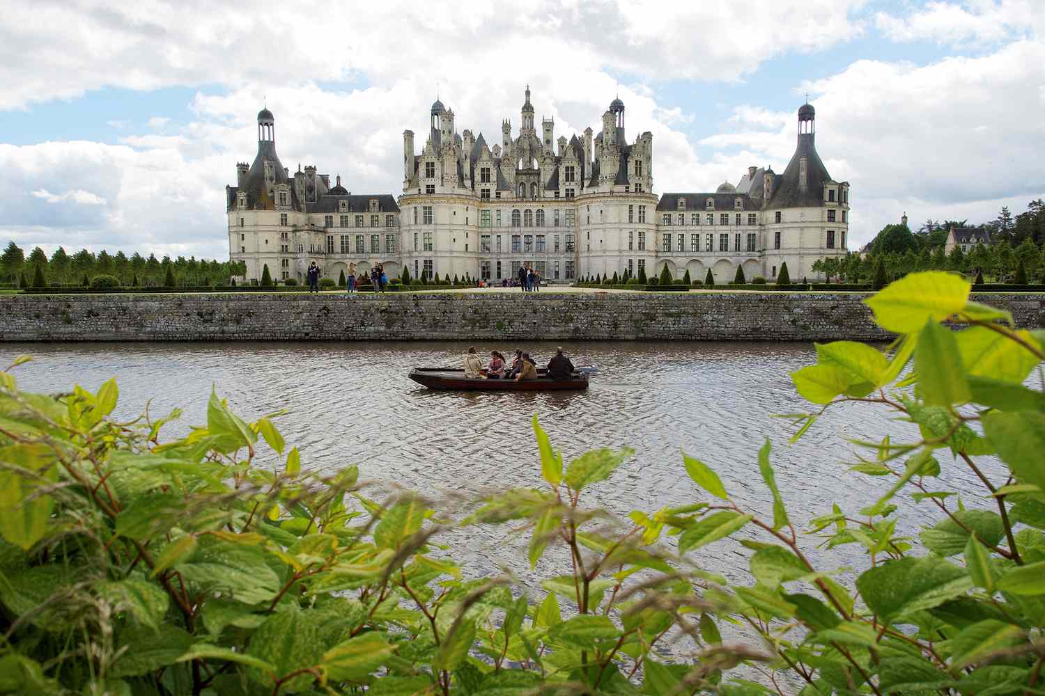 Des visiteurs naviguent sur un bateau près du château de Chambord