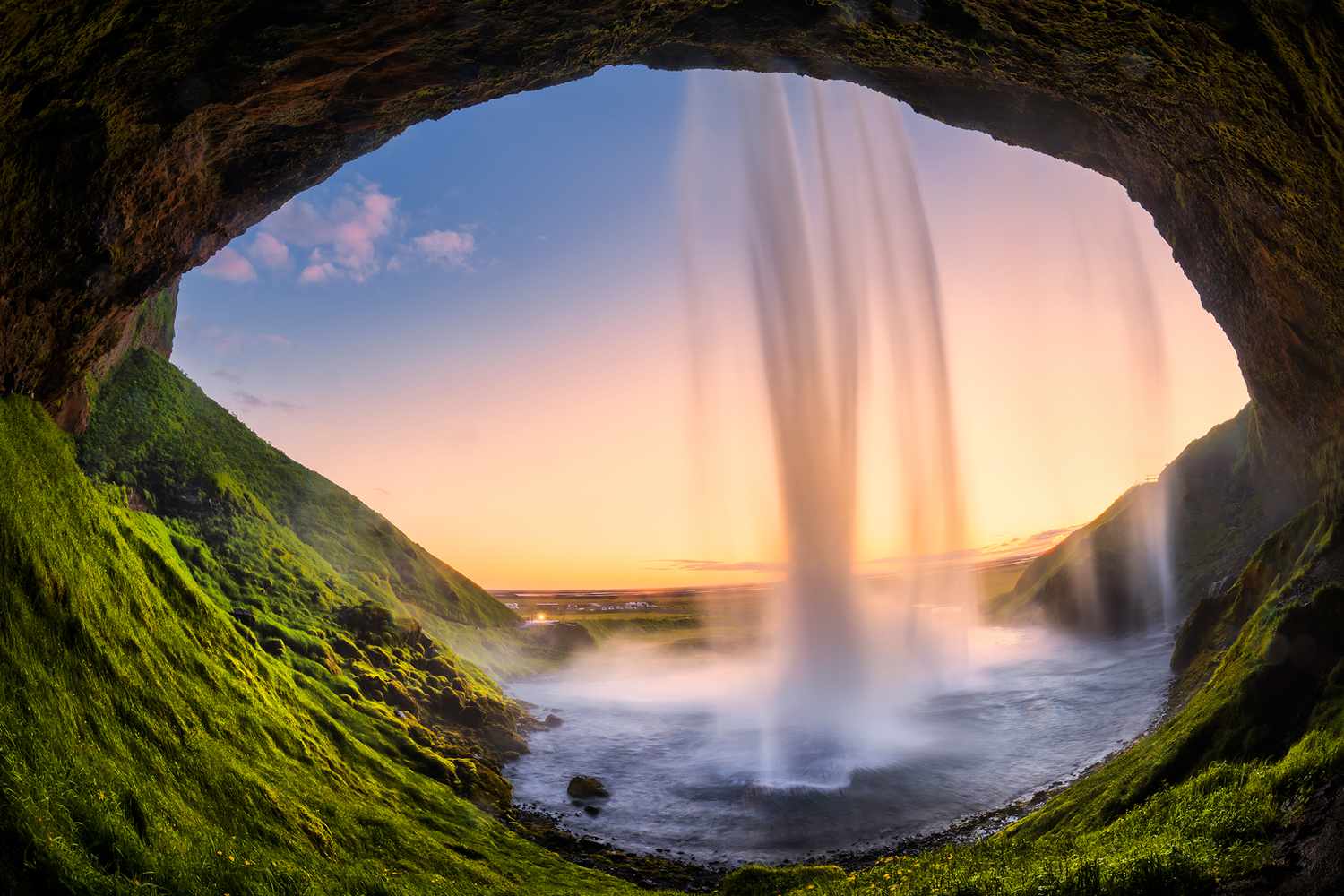 Vue depuis l'arrière de la cascade Seljalandsfoss en Islande au coucher du soleil