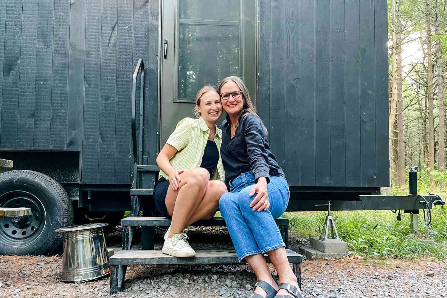 Deux femmes assises sur les marches d'une petite maison