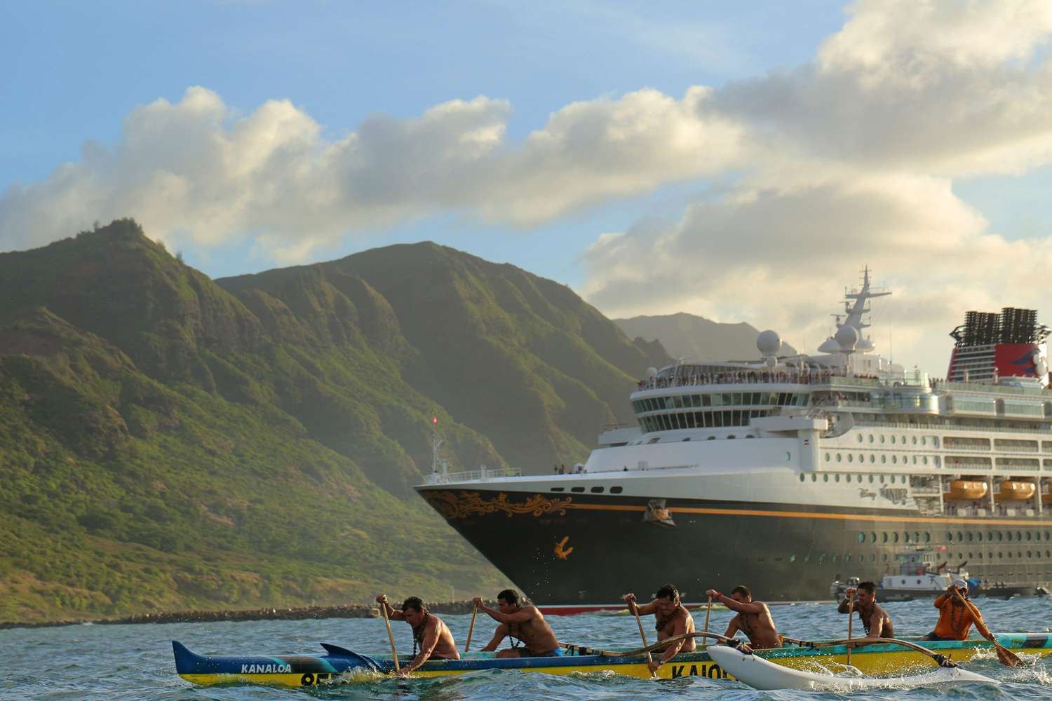 Navire de croisière Disney approchant d'Hawaï aux côtés de rameurs