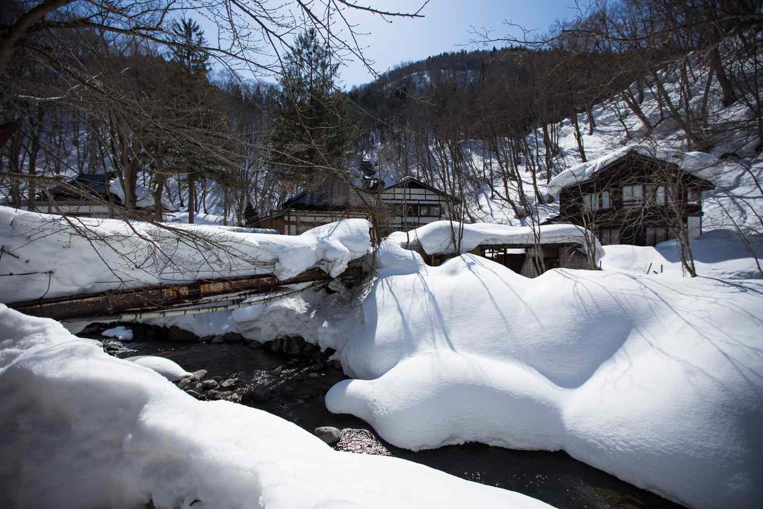 Vue extérieure du Kuroiski Onsen Aoni (bâtiments en forme de cabane), couvert de neige