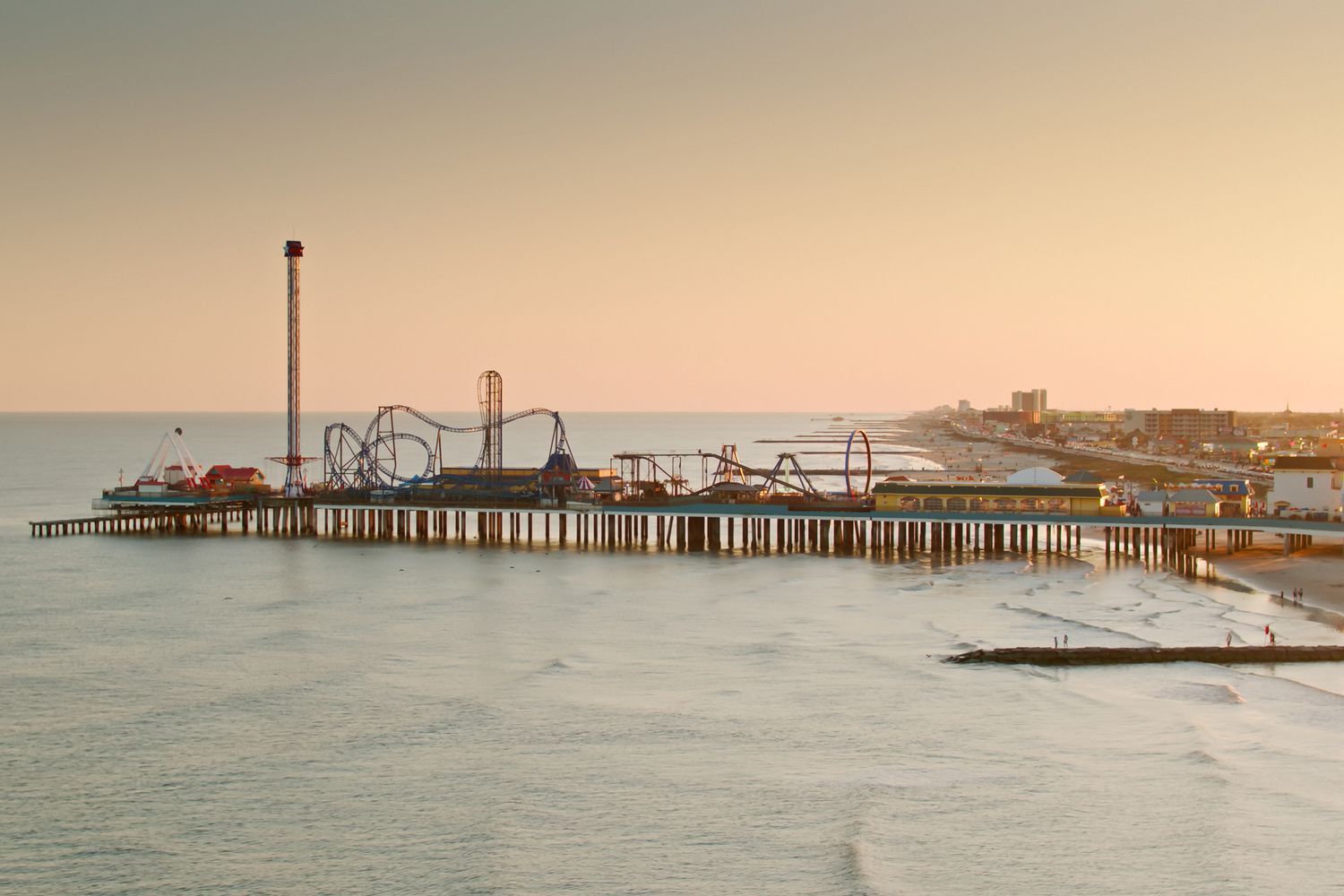 Vue aérienne de la jetée historique et de la plage à Galveston, Texas, au coucher du soleil. Une autorisation a été obtenue de la FAA pour cette opération dans un espace aérien restreint.
