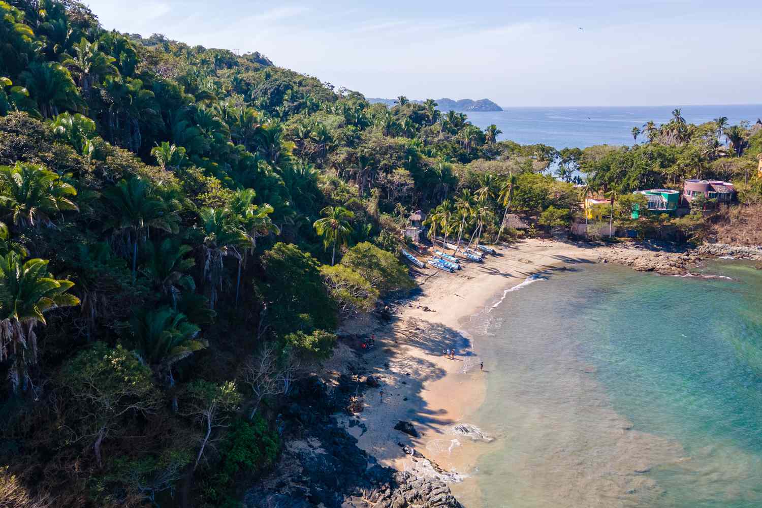Vue aérienne d'une petite plage secrète entourée de palmiers tropicaux à San Pancho, Nayarit, Mexique.