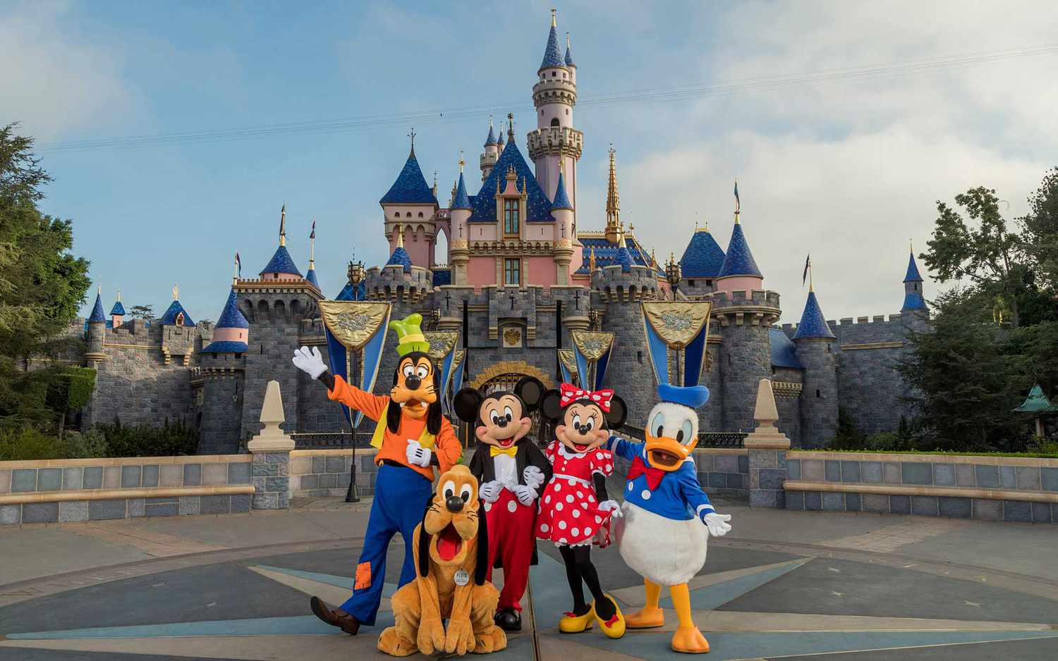 Les personnages Disney, Dingo, Pluto, Mickey, Minnie et Donald Duck devant le château à Disneyland en Californie