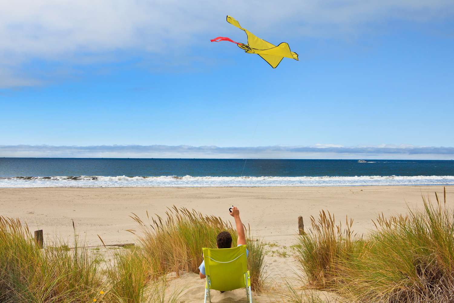 Homme assis à Stinson Beach en train de faire voler un cerf-volant