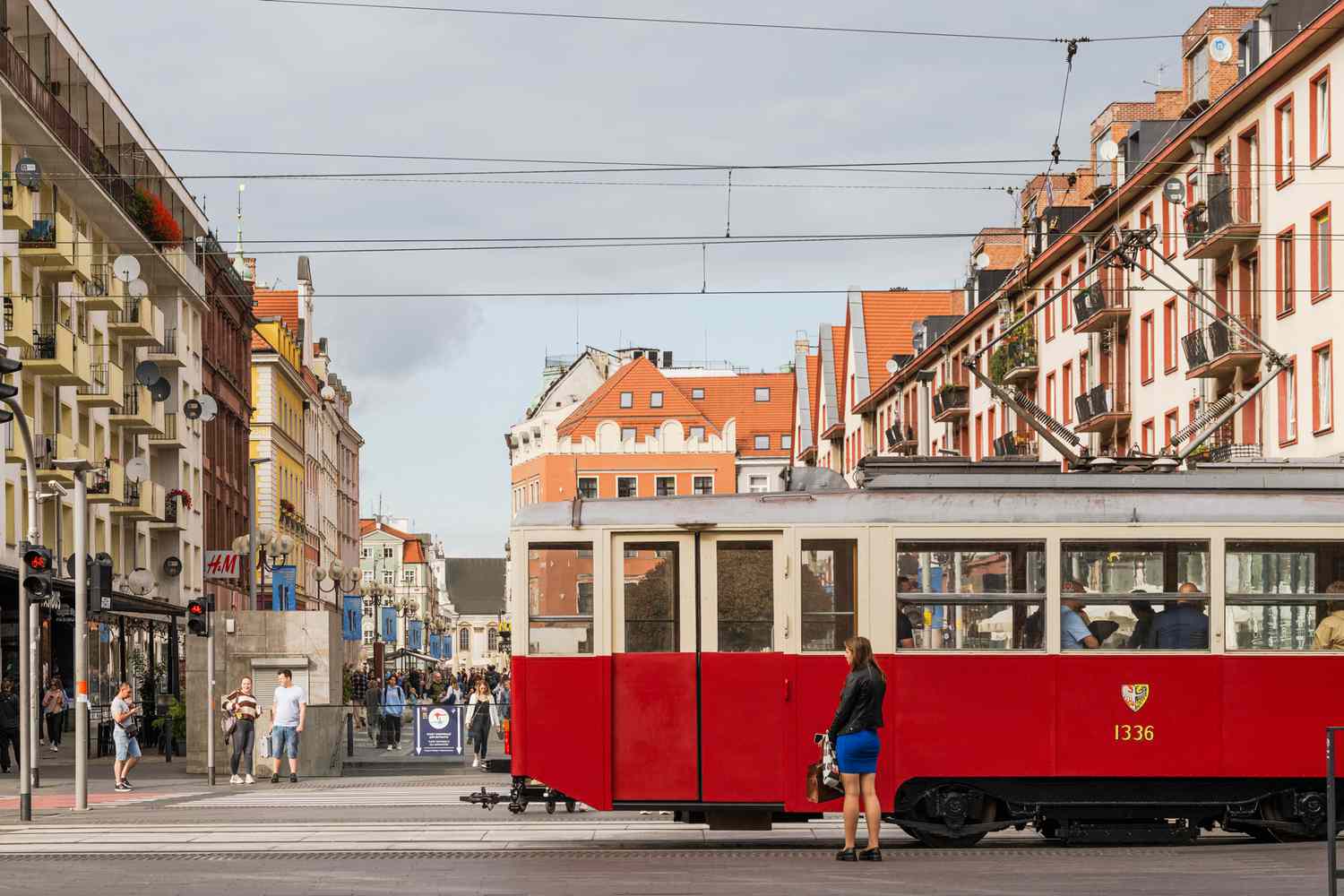 Un tram rouge traverse une rue en Pologne