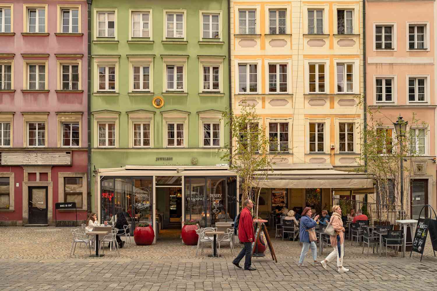 Des gens marchent devant des façades de bâtiments colorés en Pologne