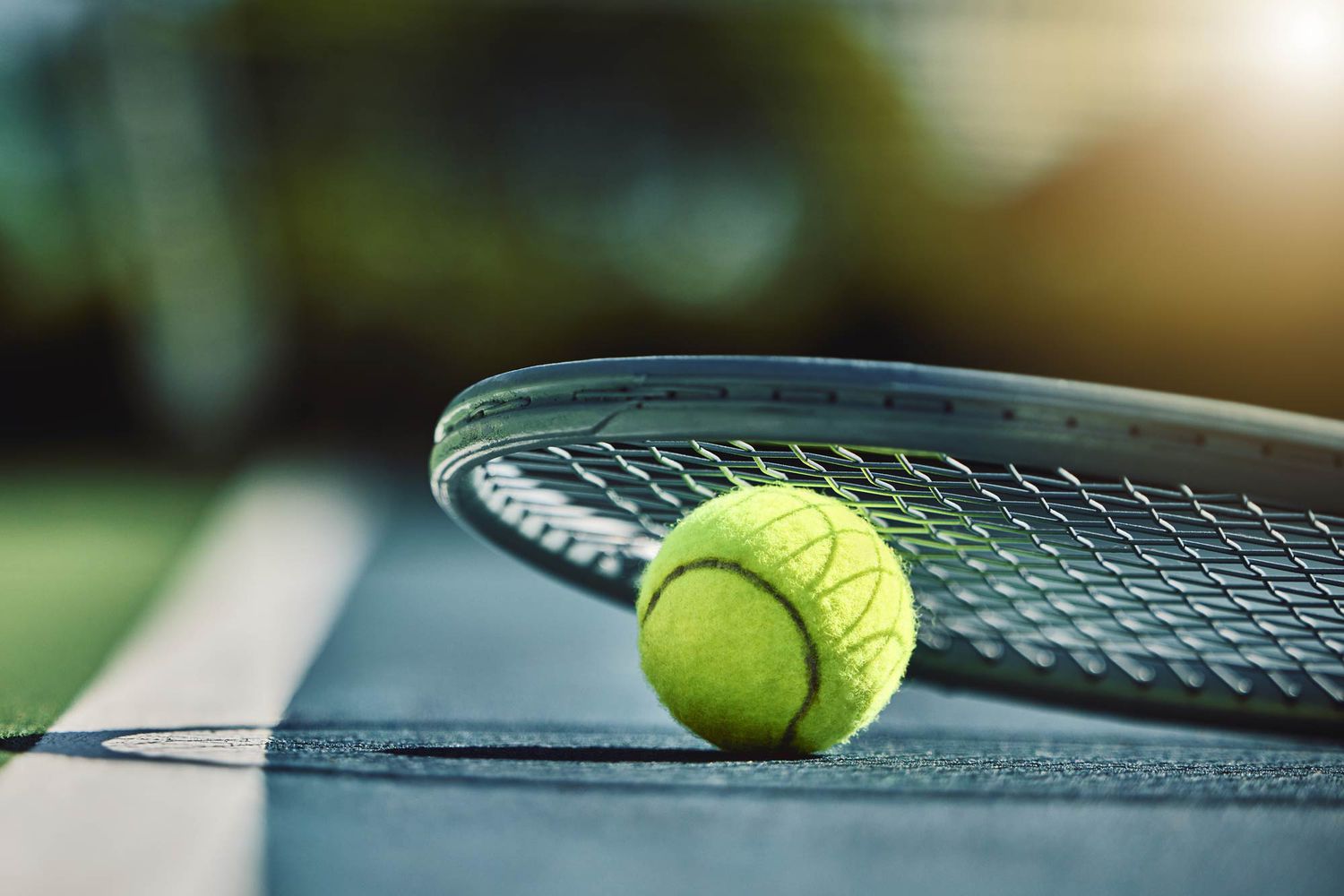 Balle de tennis, raquette et court de tennis en arrière-plan, flou, en plein air au soleil