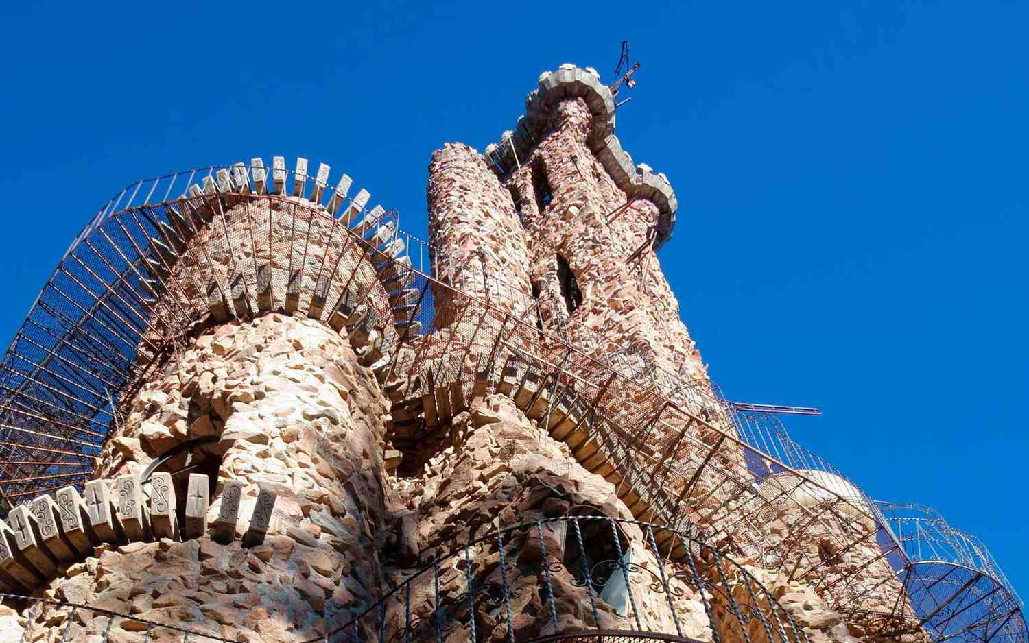 The quirky stone facade and iron balconies of Colorado's Bishop Castle jut into a blue sky