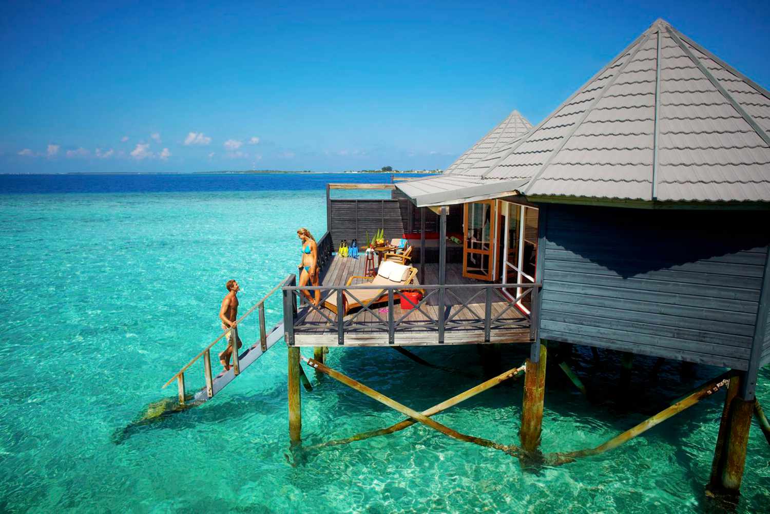 Couple entrant dans l'eau depuis un bungalow
