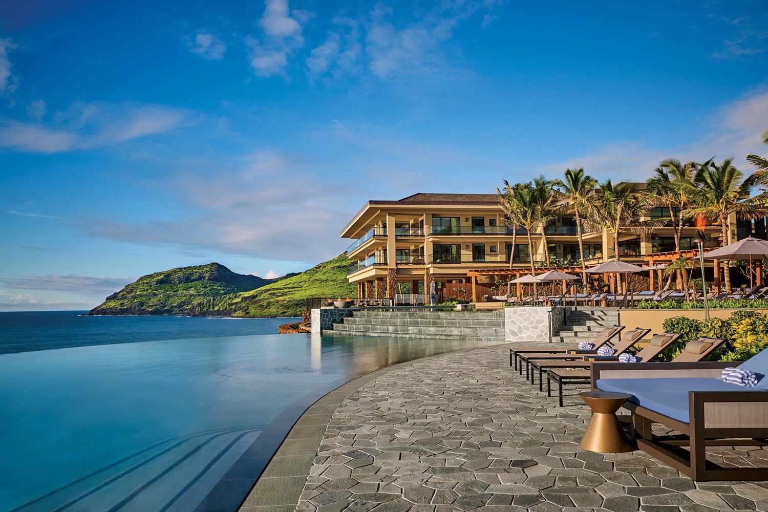 Piscine à débordement avec vue sur l'océan et chaises longues au complexe Timbers à Kauai