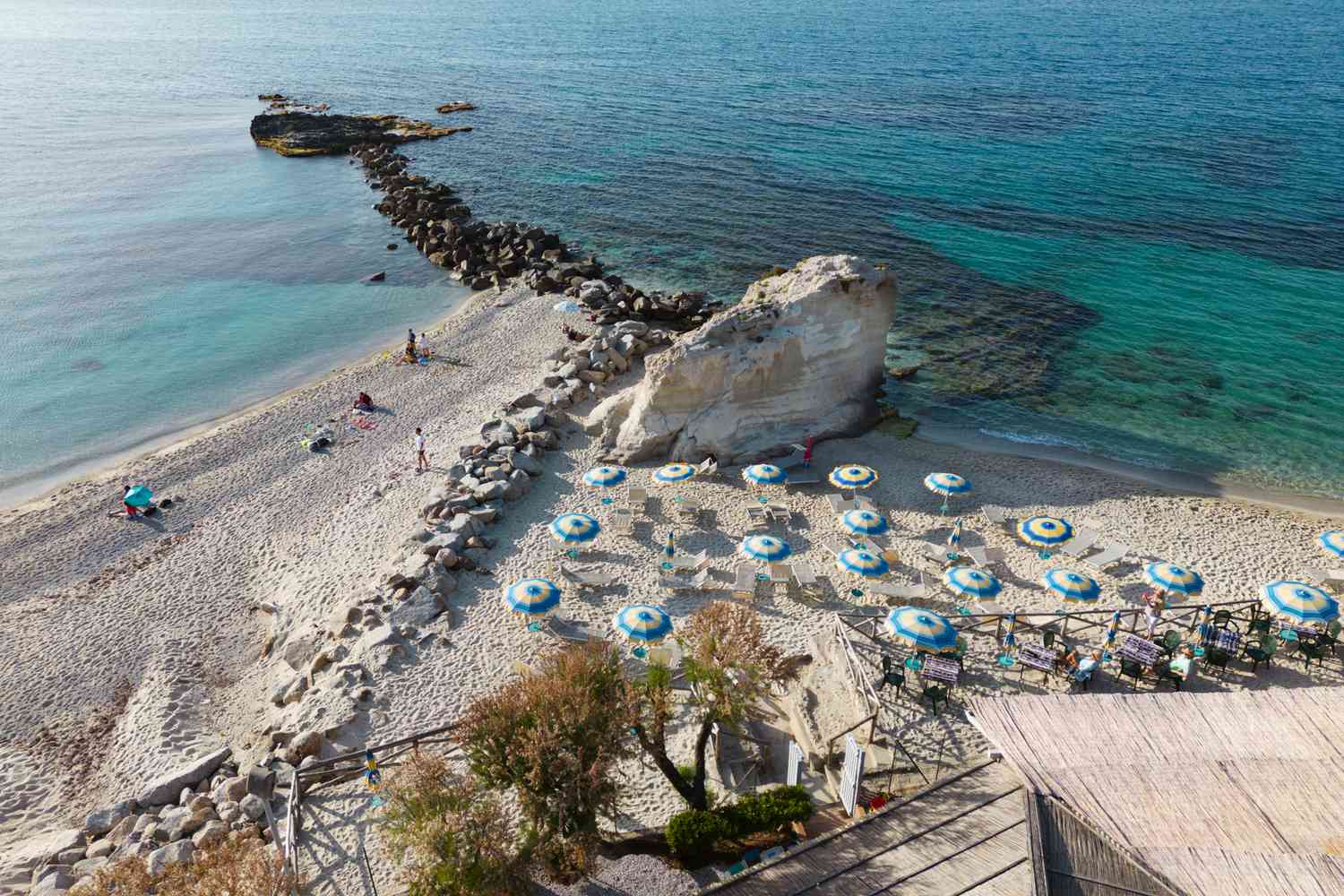 Vue aérienne de gens se détendant sur la plage de sable avec des parasols. Tropea, côte tyrrhénienne, province de Vibo Valentia, Calabre, sud de l'Italie