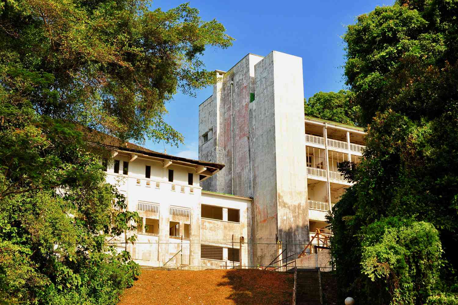 Extérieur de l'hôpital abandonné encadré par des arbres