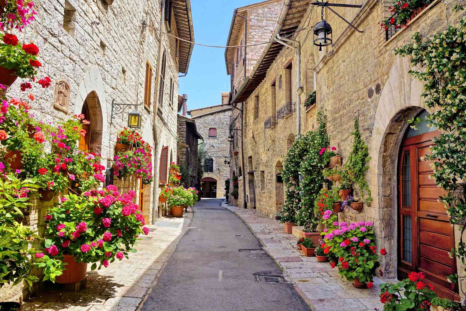 Belle rue remplie de fleurs dans la vieille ville médiévale d'Assise, Ombrie, Italie