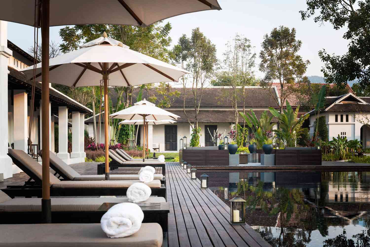 Chaises longues au bord de la piscine de Sofitel Luang Prabang