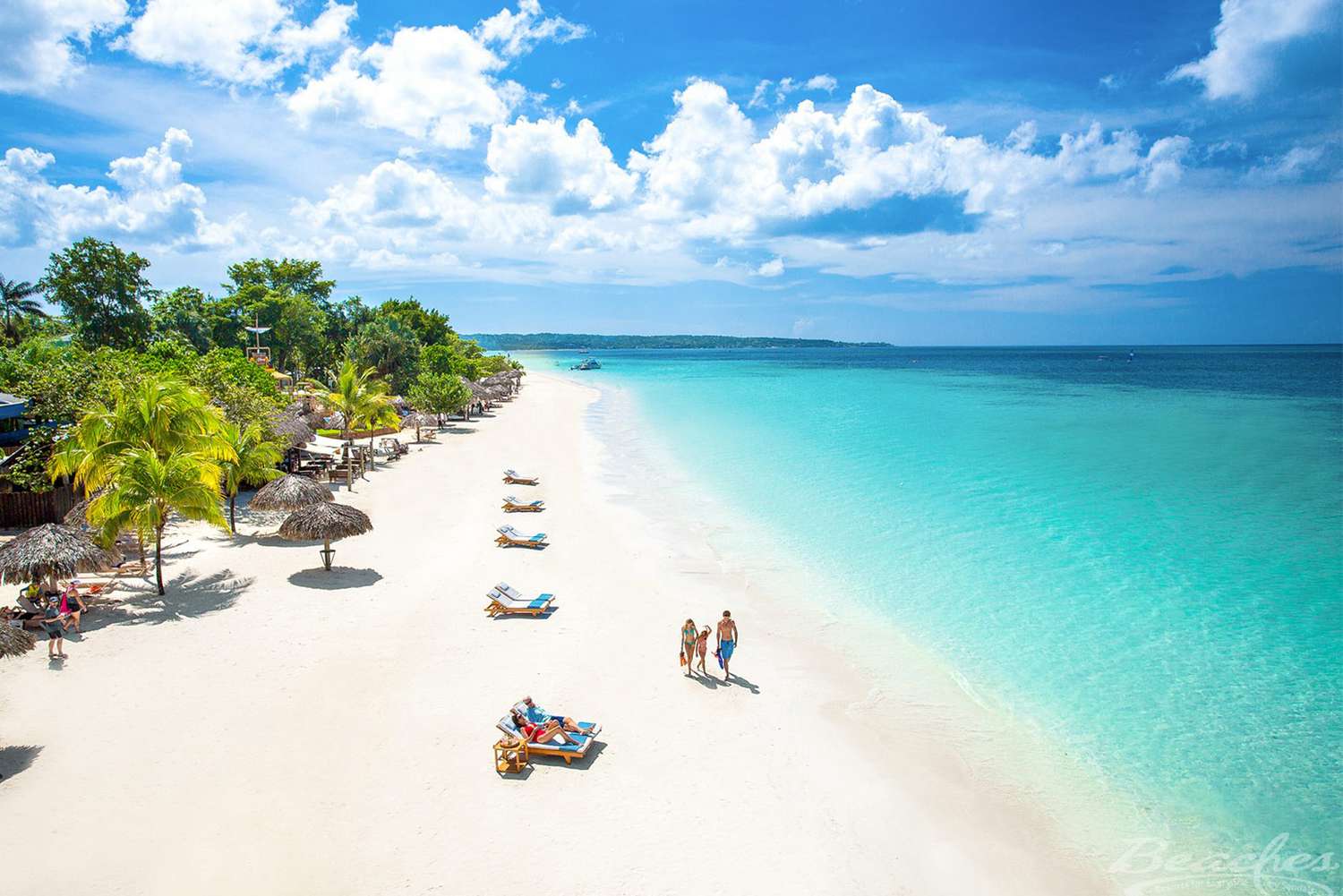 Vue aérienne d'une famille marchant sur la plage près des baigneurs à Negril