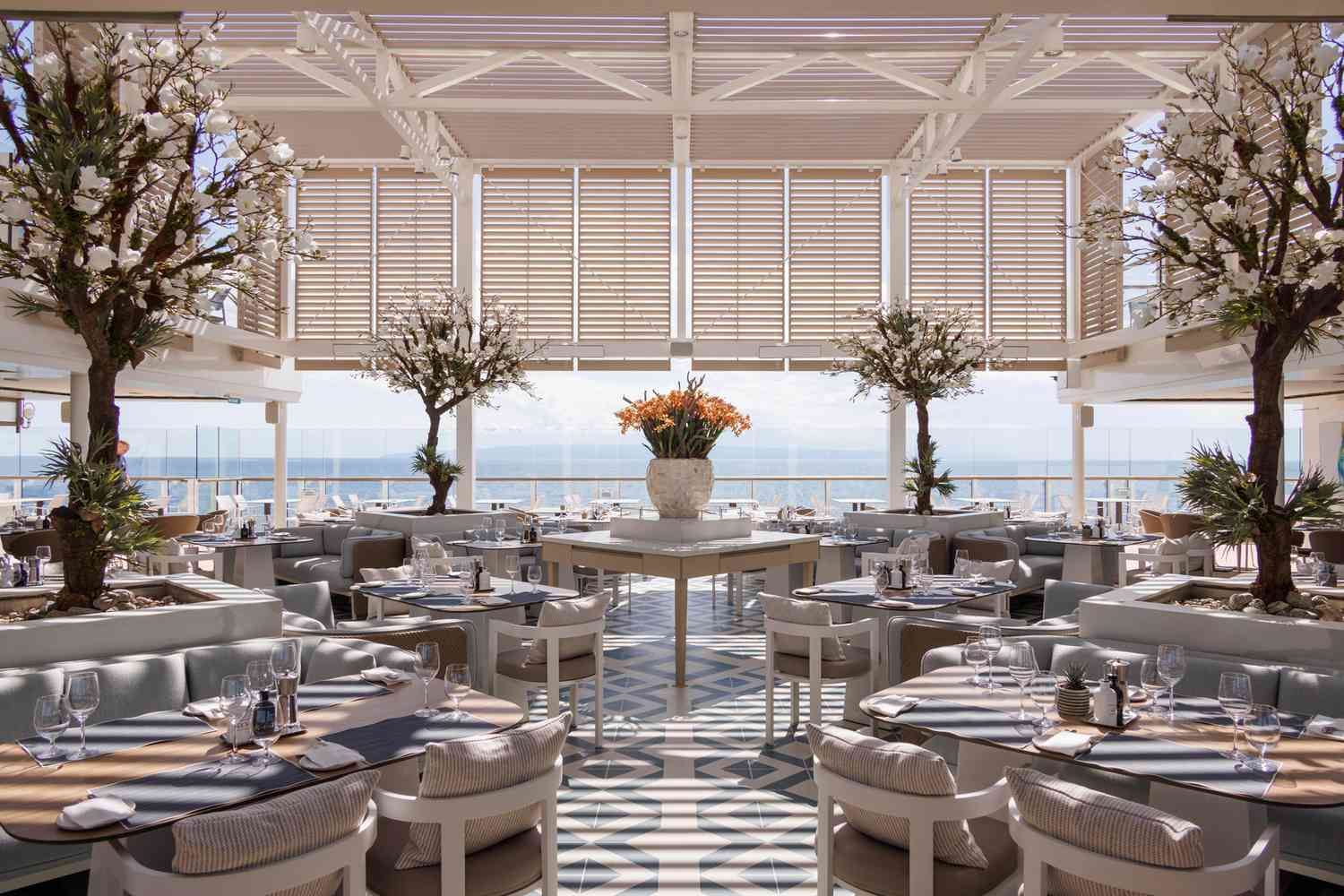 Un restaurant sur un bateau de croisière avec des tables au design blanc et bleu