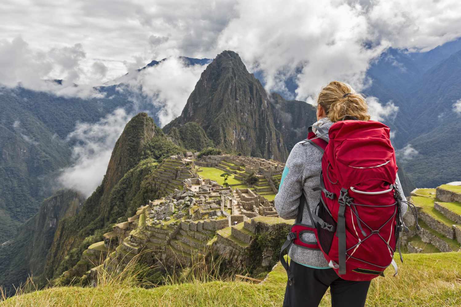 Pérou, Andes, Vallée Urubamba, touriste avec un sac à dos rouge à Machu Picchu avec la montagne Huayna Picchu