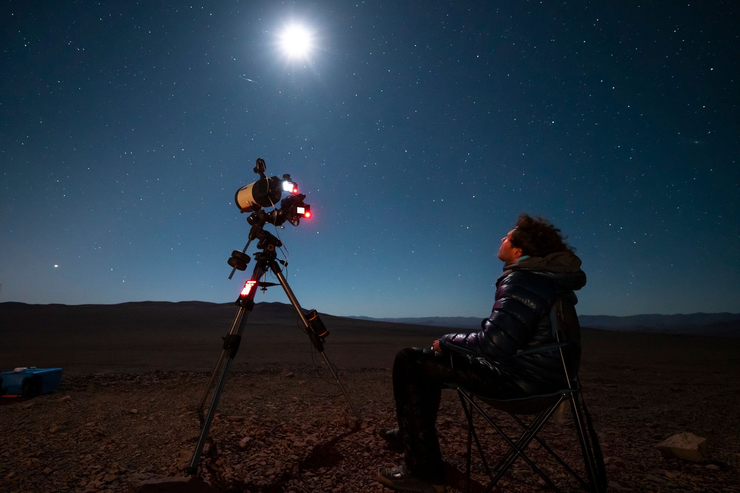 Un astronome regardant le ciel nocturne à travers un télescope amateur